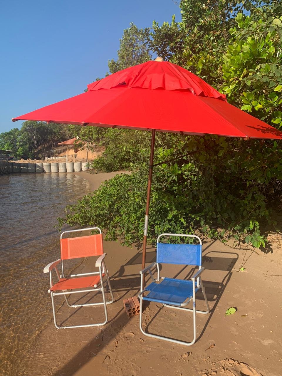 Guarda-sol e cadeiras na praia de rio